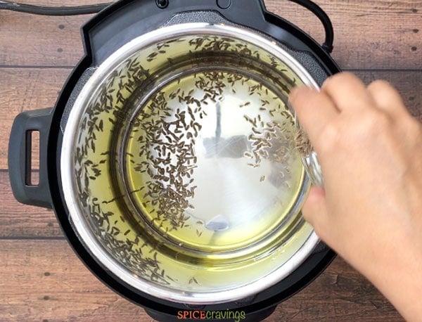 Adding cumin seeds to the melted ghee
