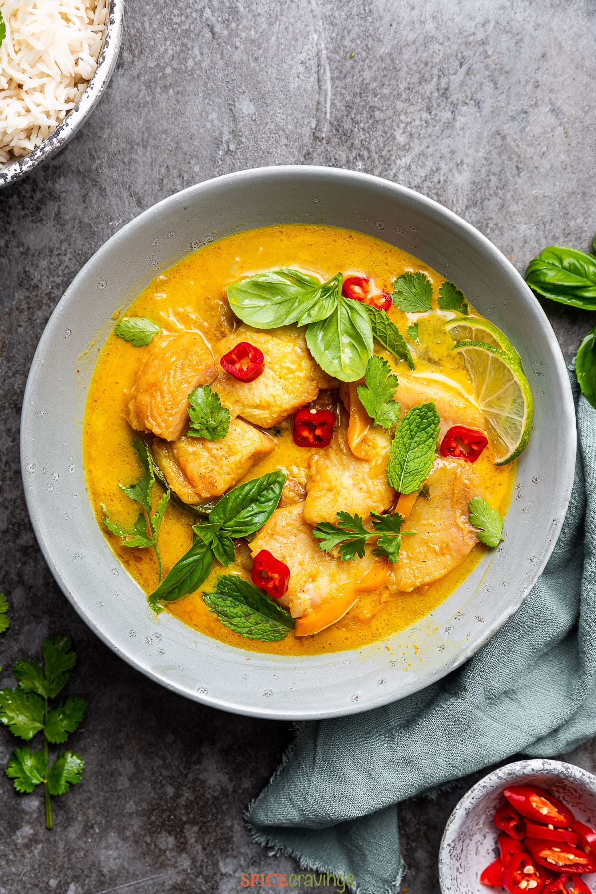 Coconut fish curry with fresh herbs in grey bowl