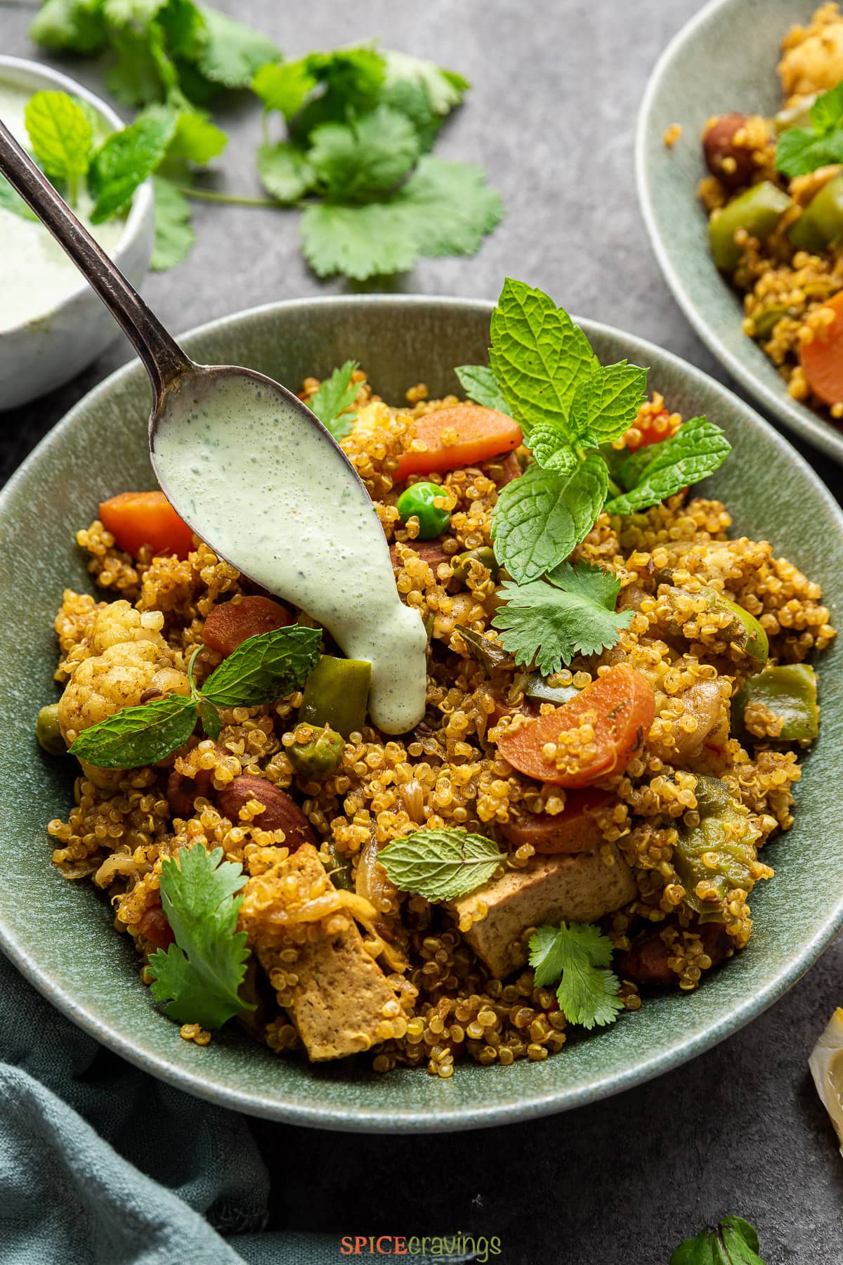 Quinoa and vegetable pilaf being topped with mint raita
