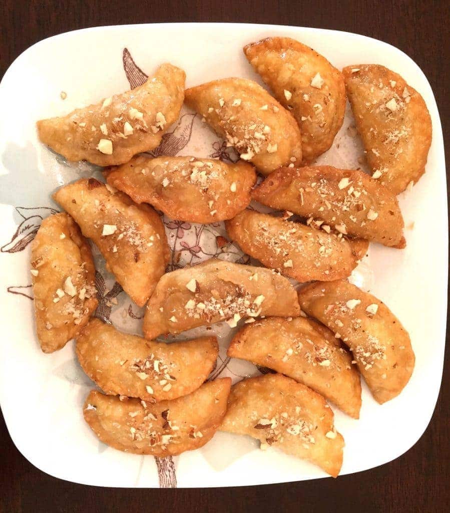 Deep Fried Gujiya, by Spice Cravings. Deep Fried Gujiya, or Milk Fudge Turnovers, are a popular dessert made in the northern part of India around the festivals of Holi and Diwali. It is a deep-fried sweet dumpling that is made by stuffing pastry dough with sweetened milk fudge (khoya), chopped nuts and coconut flakes and is glazed with a thick sugar syrup. #cooking #food #recipe #recipes #foodphotography #foodblogger #yummy #delicious #foodie