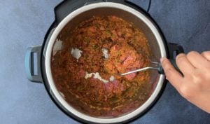Mixing ground meat in curry mix