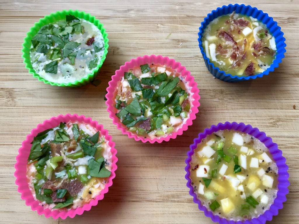 Egg bites topped with an assortment of cheese, meats and vegetables