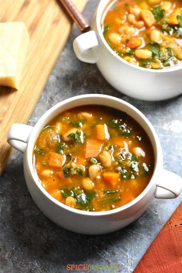 Two soup bowls with minestrone soup with beans, carrots, spinach and quinoa