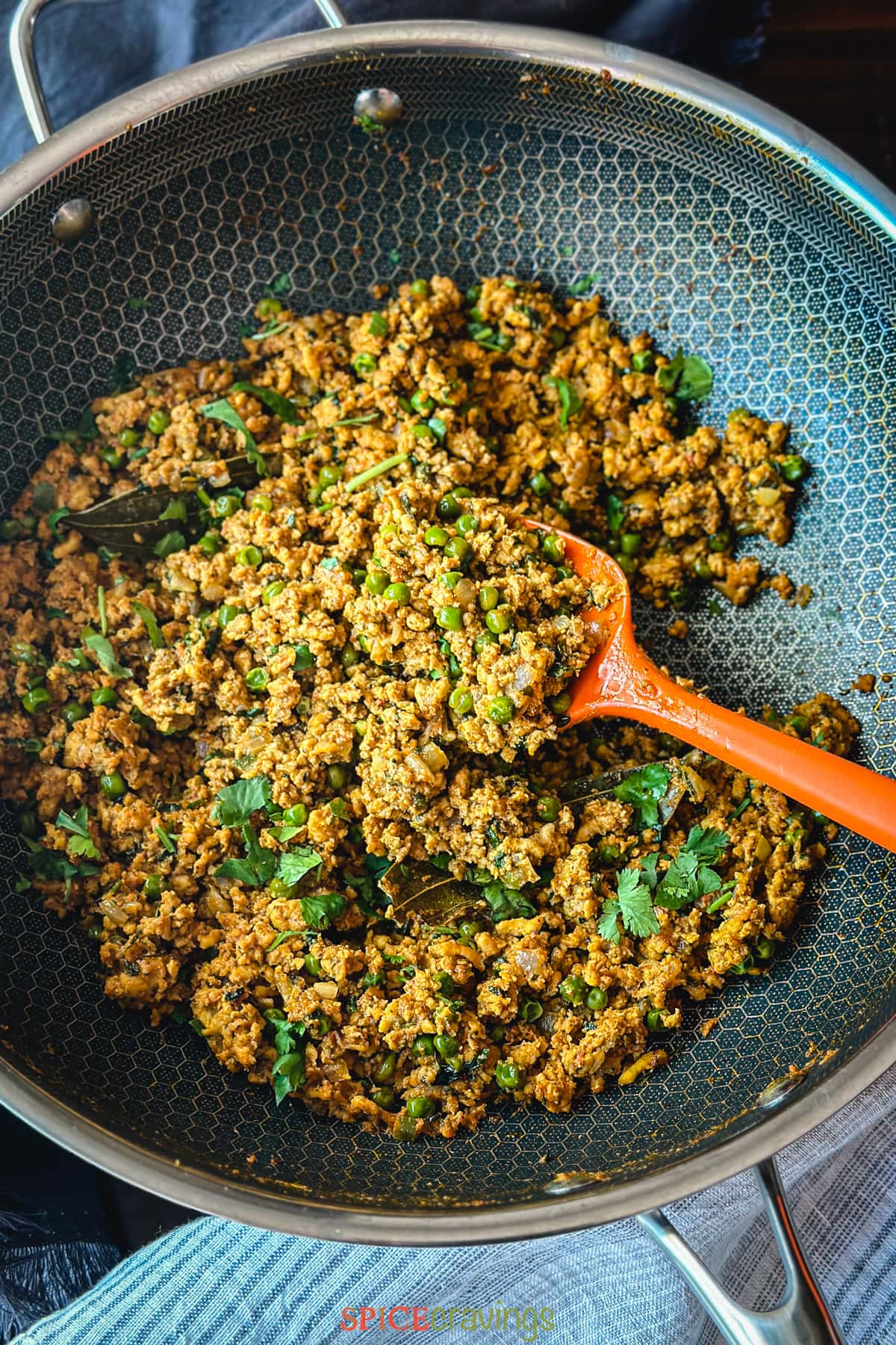 Indian spiced ground meat and peas, Keema Matar, served in a copper bowl, garnished with cilantro