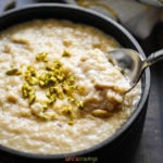 Bowl of Indian rice pudding garnished with chopped pistachios