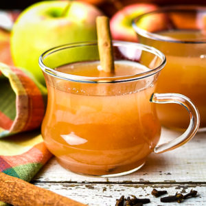 mulled cider served in a cup with cinnamon stick