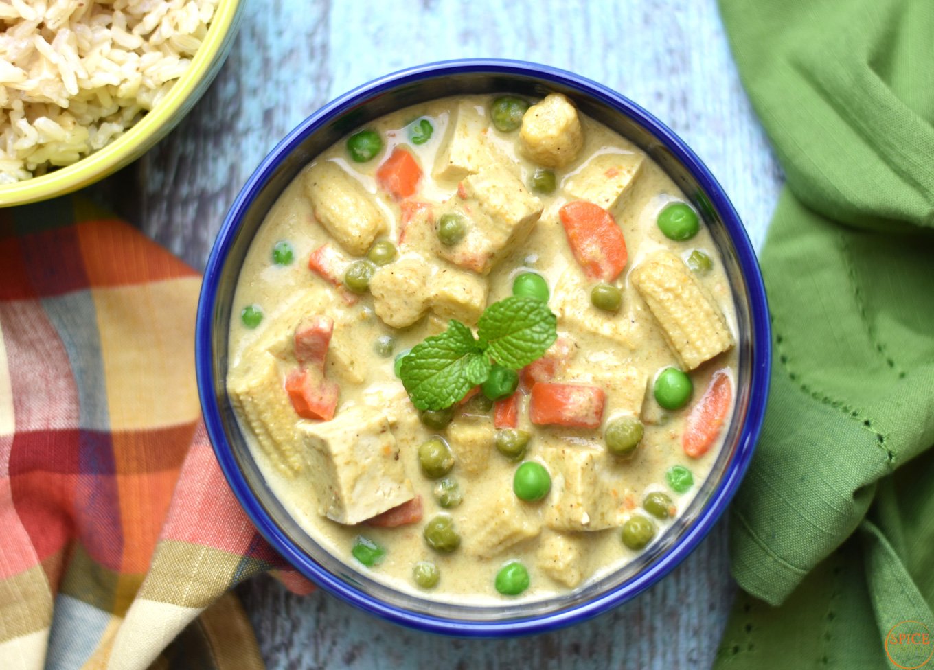 Green curry with tofu and vegetables garnished with mint leaves