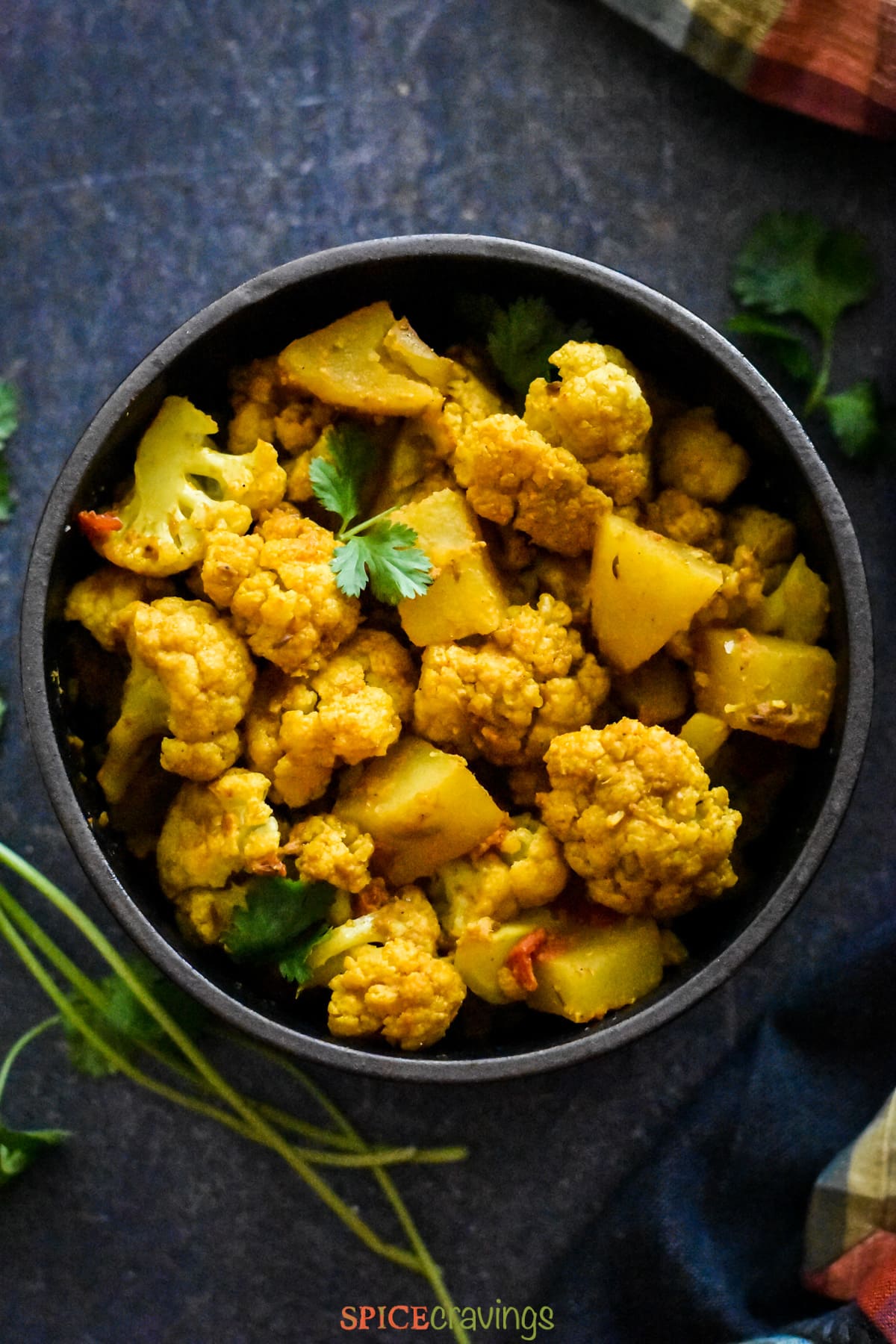 Indian spiced cauliflower and potato in black bowl