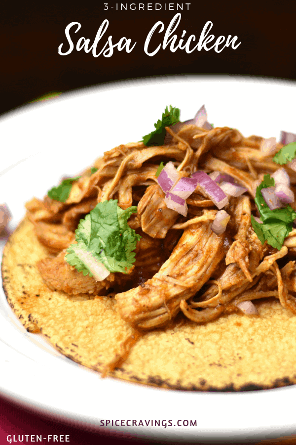 A plate of shredded salsa chicken tacos garnished with onion and cilantro