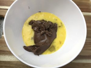 Add chocolate spread into a bowl with eggs