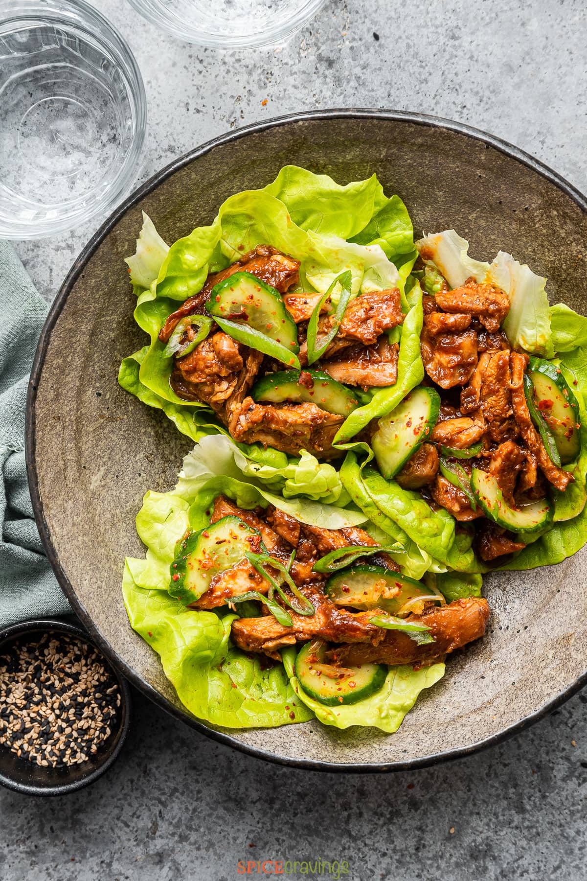 Spicy chicken served on lettuce cups with pickled cucumber