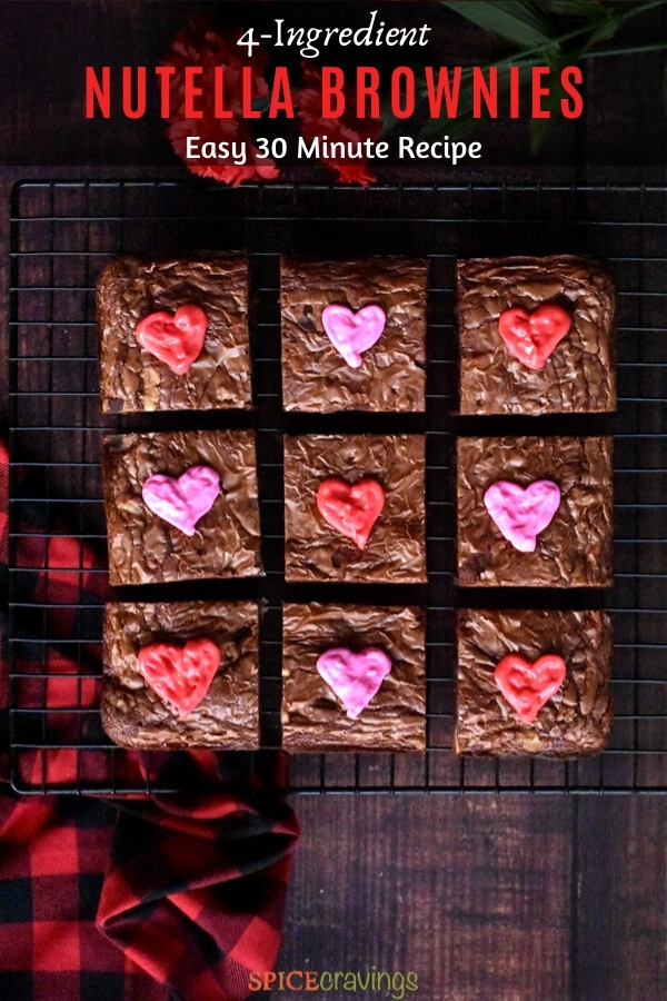 Chocolate brownies decorated with red and pink hearts resting on a cooling rack