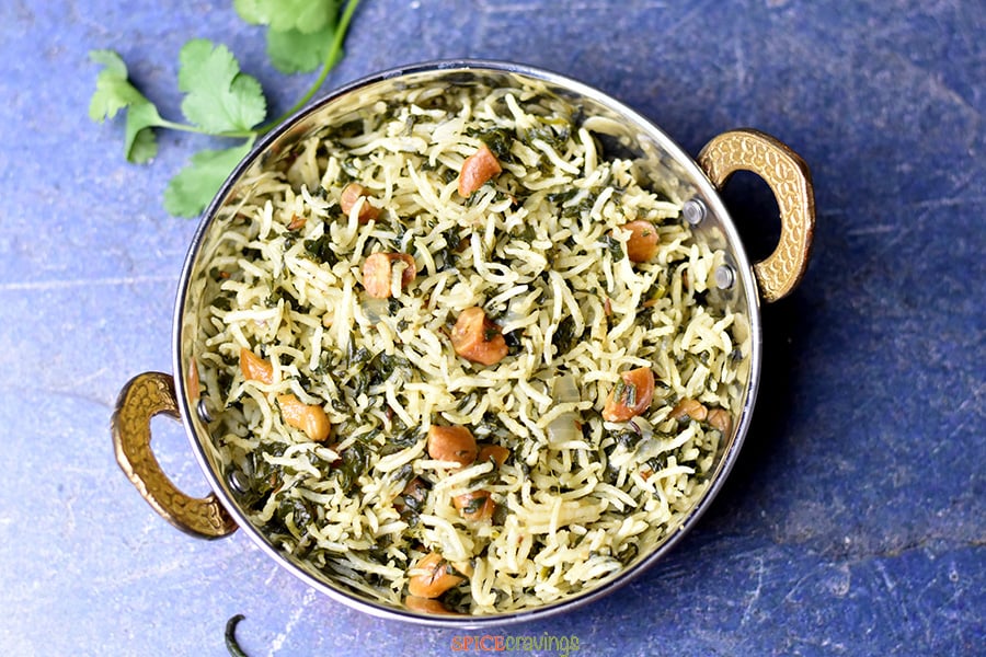 Rice cooked with spinach and spices served in a copper bowl