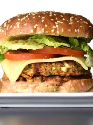 A delicious veggie bean burger, with a golden brown bean-patty, sandwiched between two warm, butter-toasted buns, the fresh crunch of lettuce and tomato, a slice of spicy pepper-jack, smothered in a sweet and spicy Sriracha-mayo sauce. by Spice Cravings. #cooking #food #recipe #recipes #foodphotography #foodblogger #yummy #delicious #foodie #instantpot