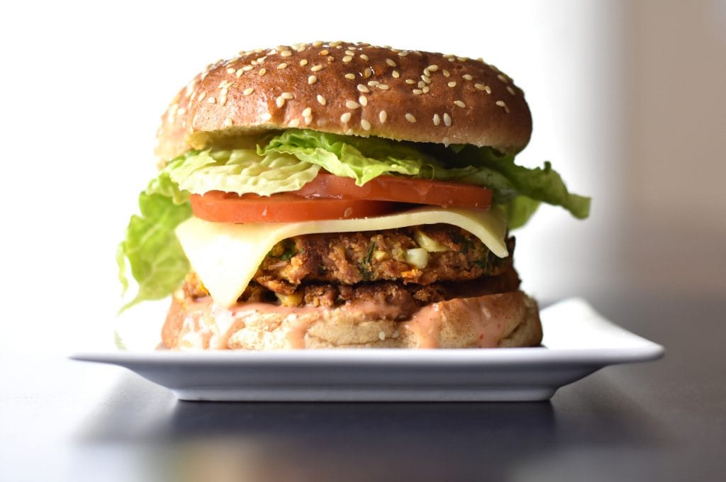 A delicious veggie bean burger, with a golden brown bean-patty, sandwiched between two warm, butter-toasted buns.