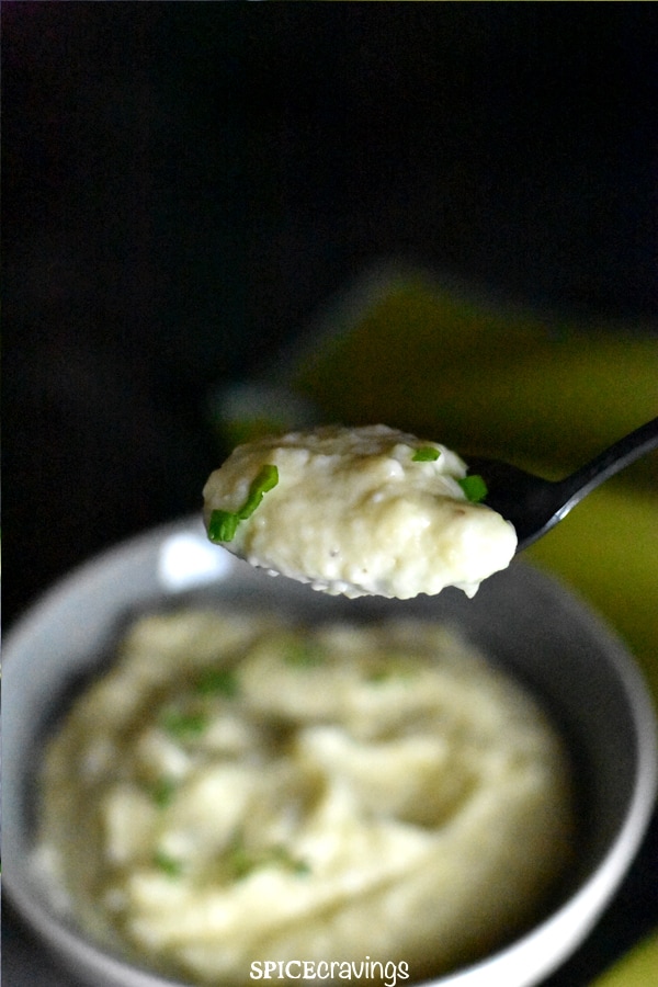 A spoonful of garlic cauliflower mashed potatoes, garnished with thyme
