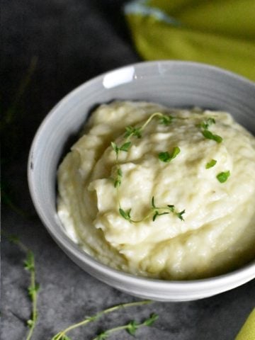 Smooth garlic cauliflower mashed potatoes served in a grey bowl