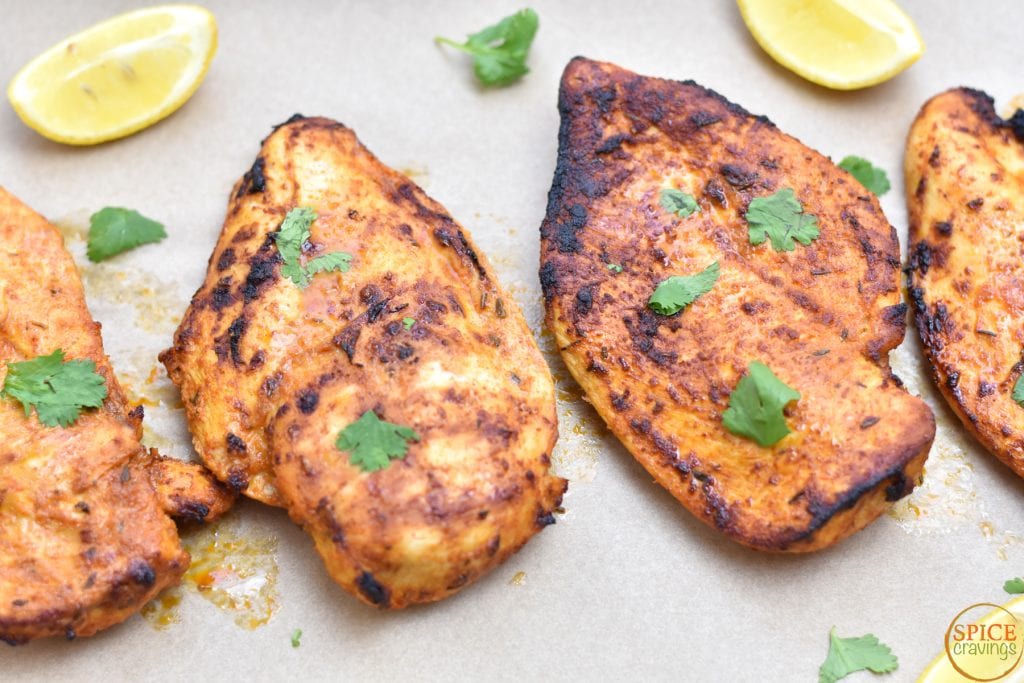 spiced grilled chicken with cilantro and lemon wedges