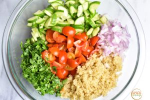 quinoa, red onion, tomatoes, cucumber, herbs in bowl