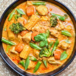 Bowl of thai curry with vegetables and chicken garnished with cilantro
