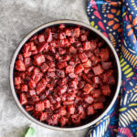 beetroot thoran recipe in black bowl with colorful kitchen towel