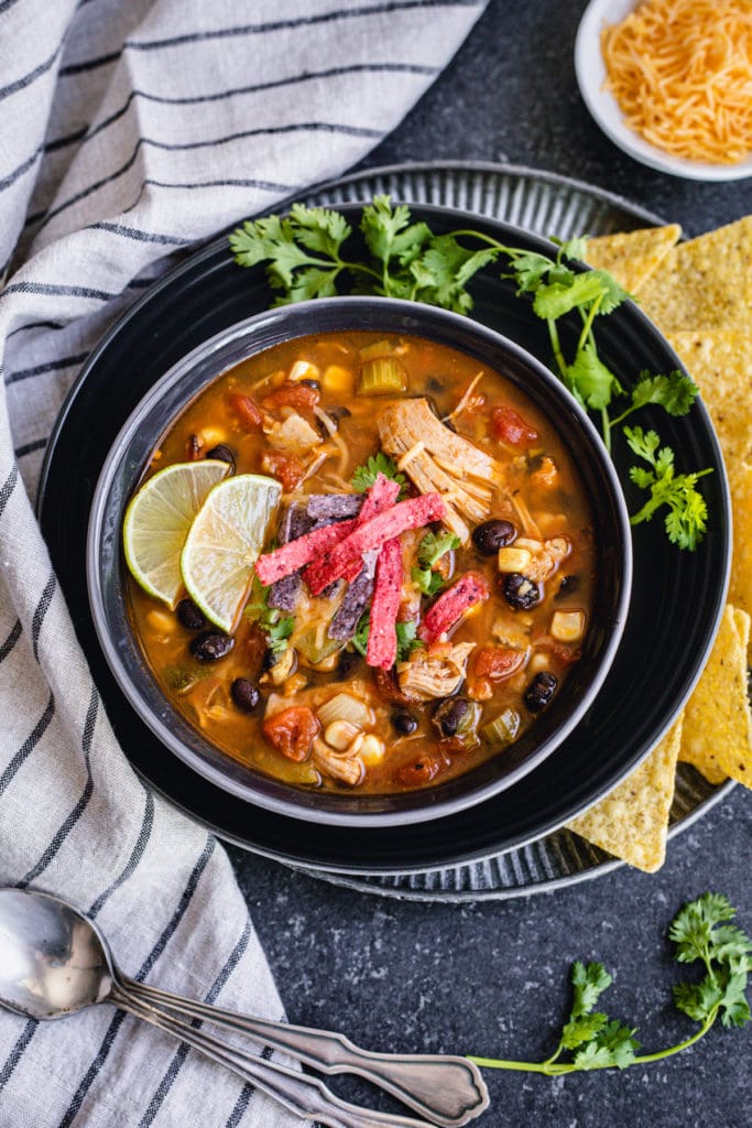 Instant pot chicken tortilla soup served with tortilla chips and lime wedges