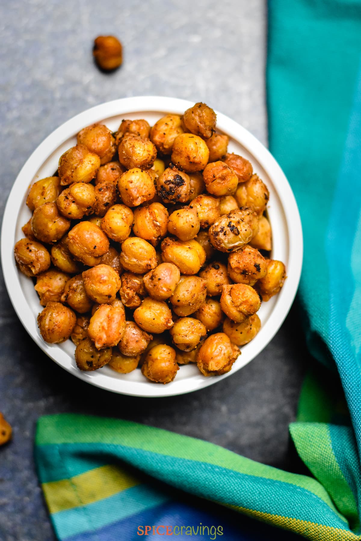 roasted chickpeas in a small white bowl with blue green towel