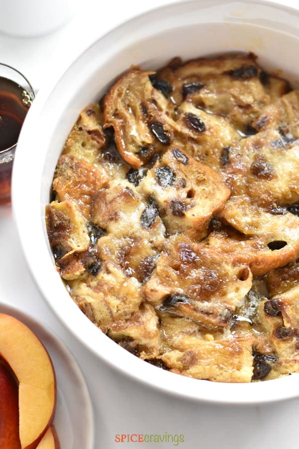 Baked French Toast Casserole served with maple syrup and sliced peaches