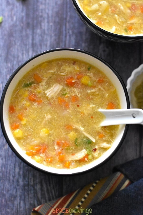 A bowl of Chicken Corn Soup with carrots and scallions