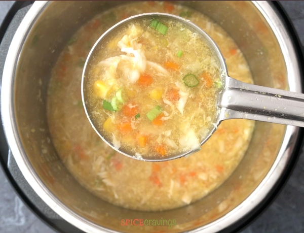 A ladle of chicken sweet corn soup cooked in the Instant Pot