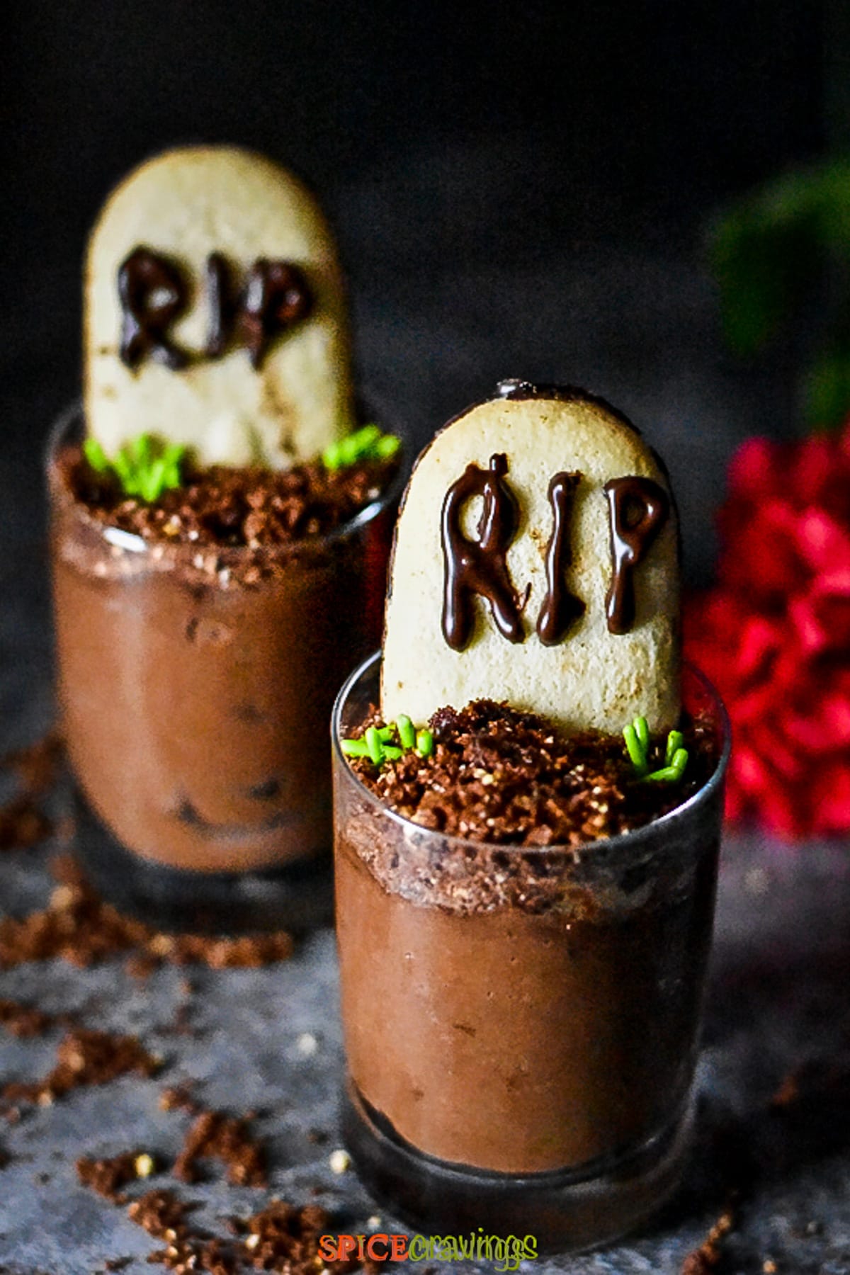 Two cups of chocolate mousse decorated like a graveyard to celebrate Halloween