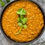 ethiopian red lentil stew in black bowl garnished with cilantro