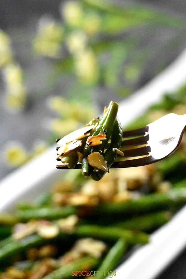 A fork loaded with Green Beans Almondine