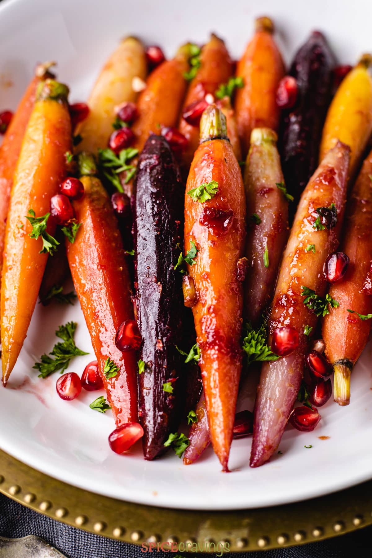 Close up of glazed carrots garnished with pomegranate seeds
