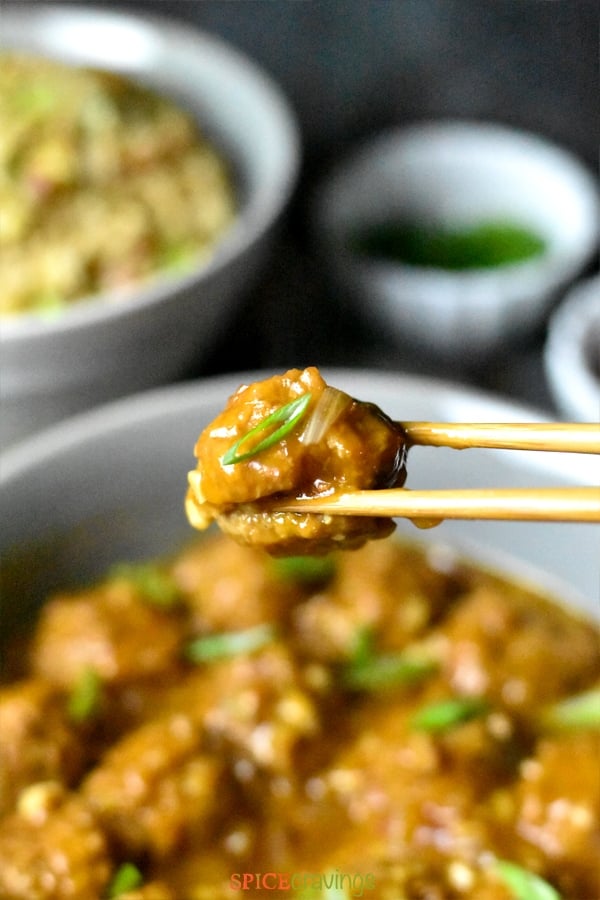 Vegetable manchurian meatball between two chopsticks