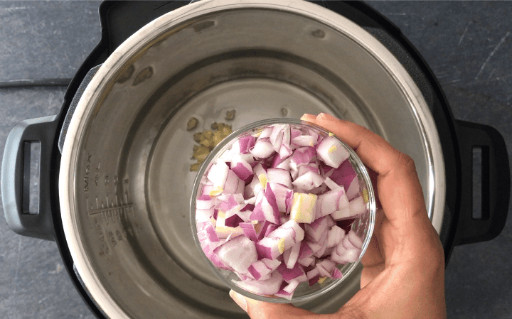 Adding chopped onions to the pressure cooker