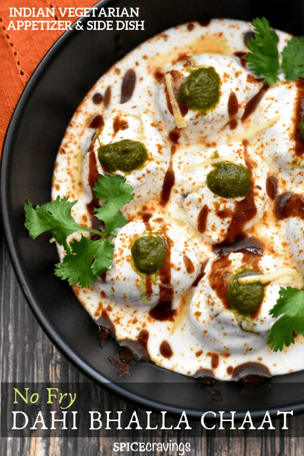 Dahi Bhalle served in a black bowl, garnished with cilantro and chutney
