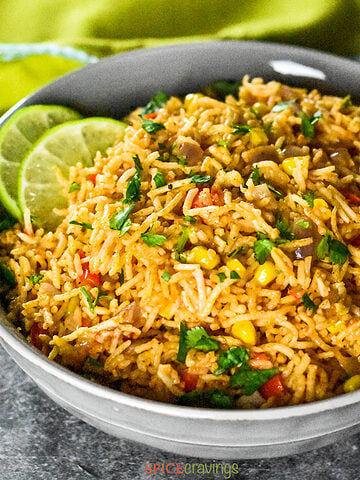 Mexican rice with corn and peppers, garnished with cilantro and lime