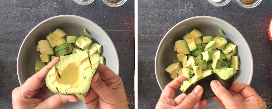 Pinching the cut avocado to release the chunks