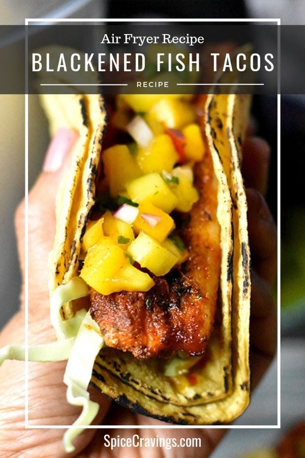 Grilled blackened fish tacos on a plate garnished with mango salsa