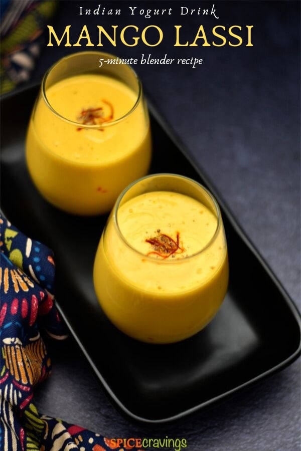 Two glasses of mango lassi placed on a black plate