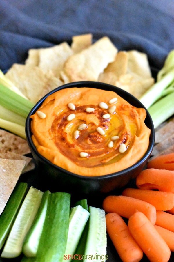 Roasted red pepper hummus garnished with pine nuts and paprika