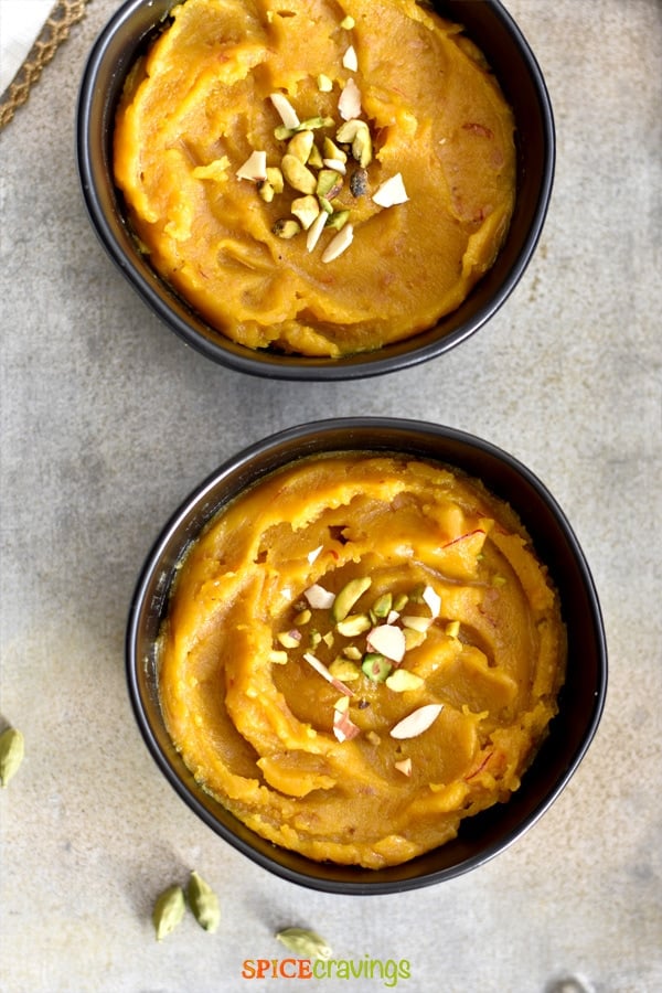 Warm Moong Dal Halwa, served in black bowls on a silver platter.