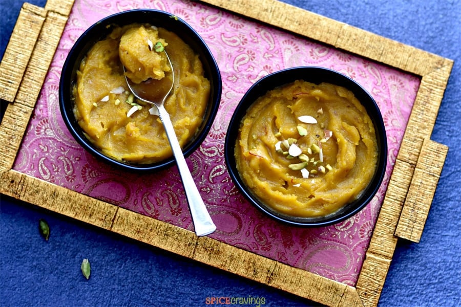Indian split lentil pudding called Moong dal halwa, served on an ethnic pink and gold tray