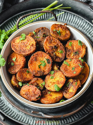 Spiced roasted potatoes in a bowl garnished with cilantro