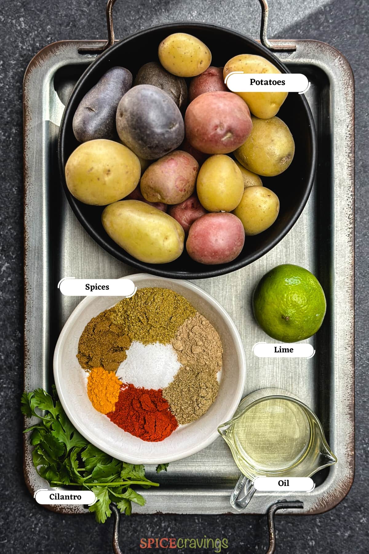 Ingredients including potato, spices, lime on metal tray