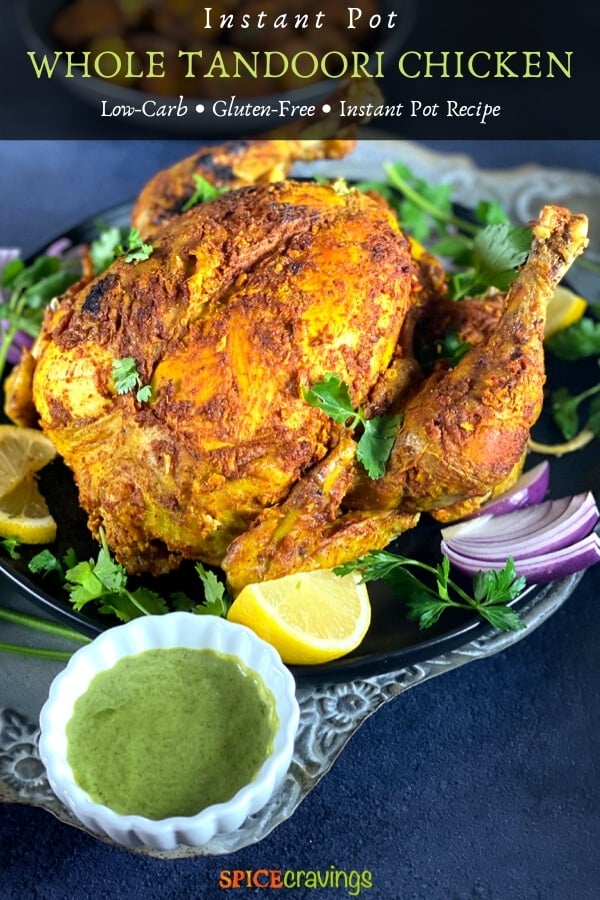 A whole roasted Chicken on a grey platter with green chutney