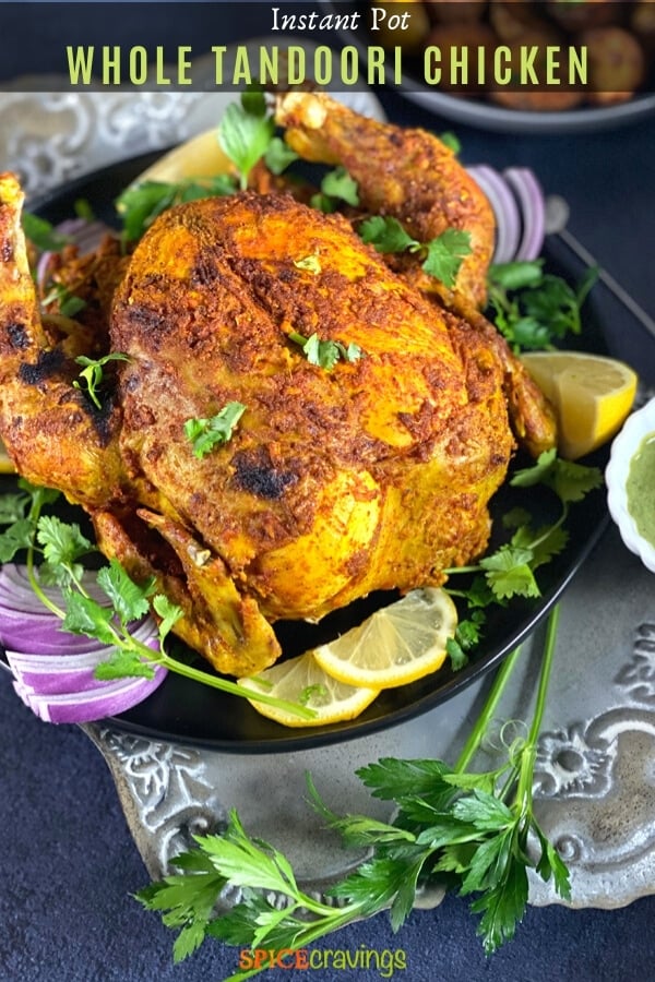 Crisp tandoori Chicken on a grey platter with lime and cilantro