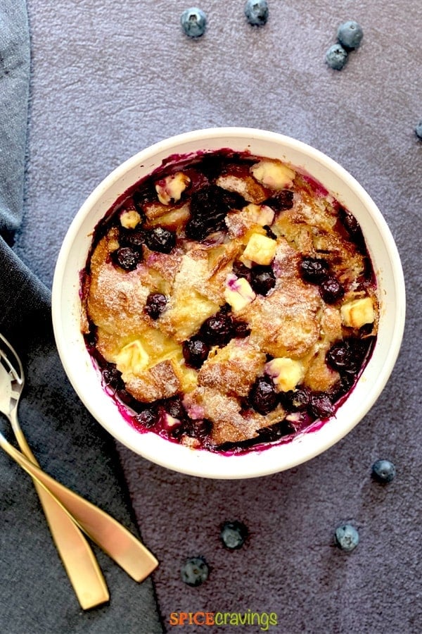 Creamy bread pudding with blueberries  in a white bowl