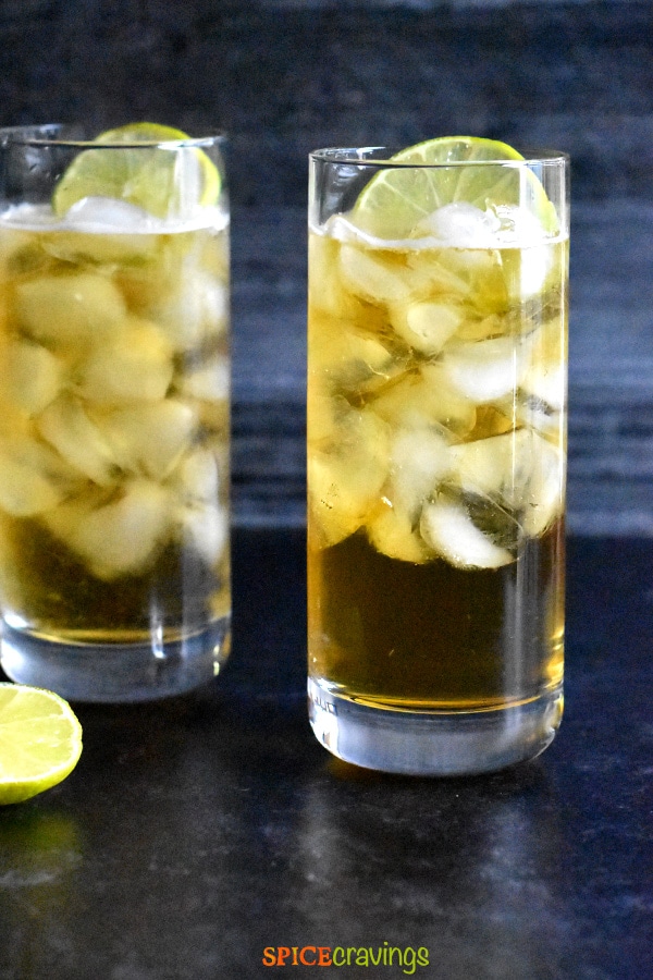 Two glasses of Dark and Stormy Cocktail with a slice of lime